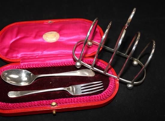 A cased silver christening pair and a silver toast rack.